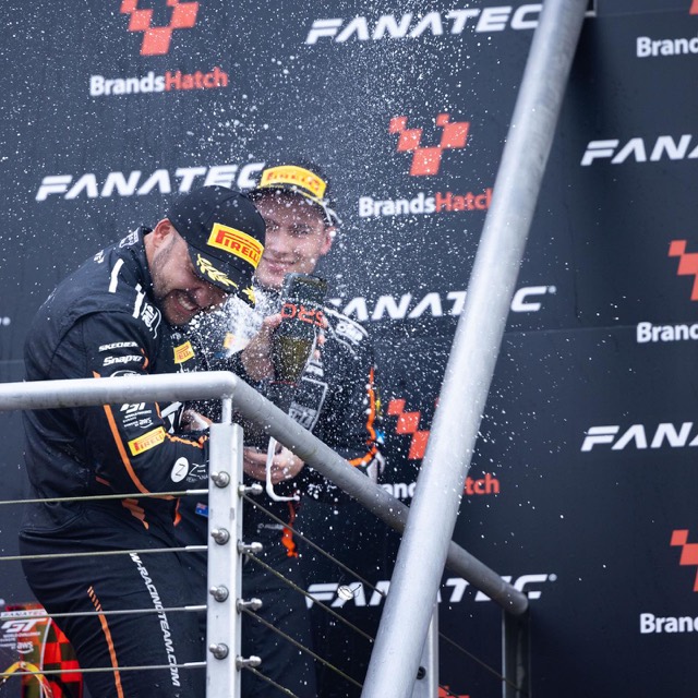 GT drivers celebrating with champagne on the podium