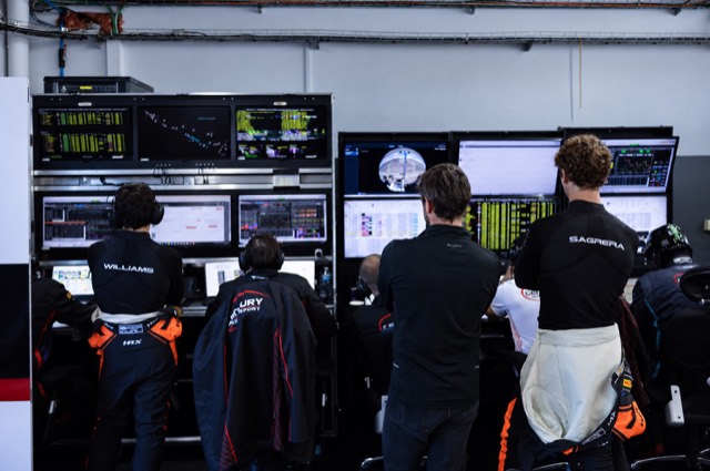 Drivers and engineers studying telemetry screens