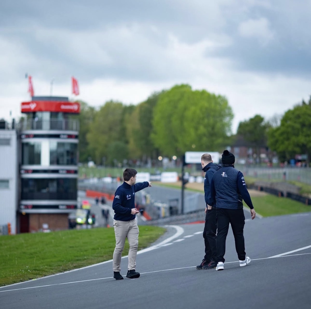 A driver and coaches discussing the circuit during a track walk